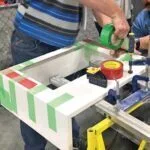 g_tape_miter.jpg Mitered corner using a measuring tape for precise woodworking and construction layout.