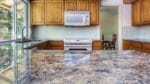 Marking a granite slab for precise cutting and shaping in stone fabrication.