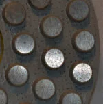 Close-up of a metallic diamond pad with dot patterns for enhanced grip.